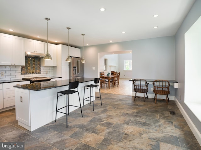 319 W Conestoga Rd, Devon, PA 19333 - kitchen featuring stainless steel refrigerator with ice dispenser, under cabinet range hood, recessed lighting, a kitchen bar, and white cabinetry