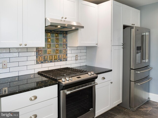 319 W Conestoga Rd, Devon, PA 19333 - kitchen featuring appliances with stainless steel finishes, under cabinet range hood, tasteful backsplash, and dark stone countertops