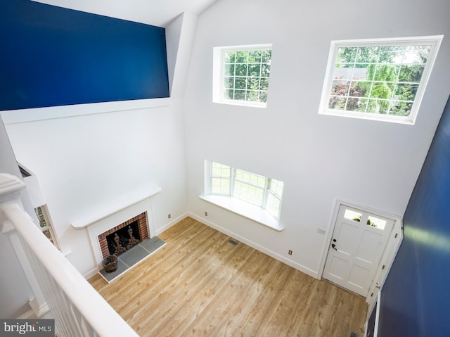 319 W Conestoga Rd, Devon, PA 19333 - unfurnished living room with high vaulted ceiling, wood finished floors, and a fireplace with raised hearth