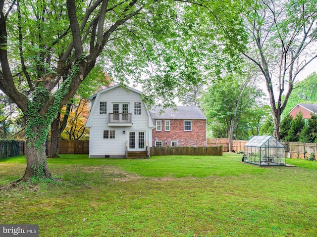 319 W Conestoga Rd, Devon, PA 19333 - back of property with french doors, a greenhouse, a fenced backyard, entry steps, and an outdoor structure