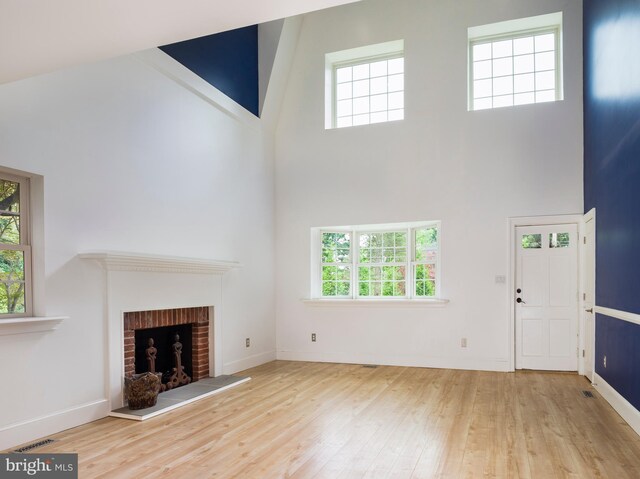 319 W Conestoga Rd, Devon, PA 19333 - unfurnished living room featuring a high ceiling, wood finished floors, and a brick fireplace