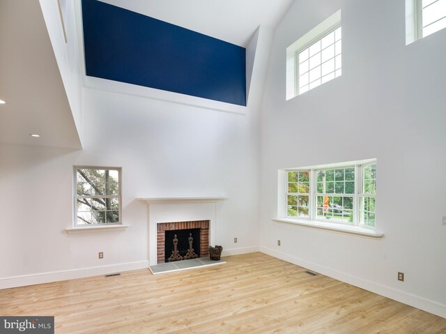 319 W Conestoga Rd, Devon, PA 19333 - unfurnished living room featuring a towering ceiling, a fireplace, and wood finished floors