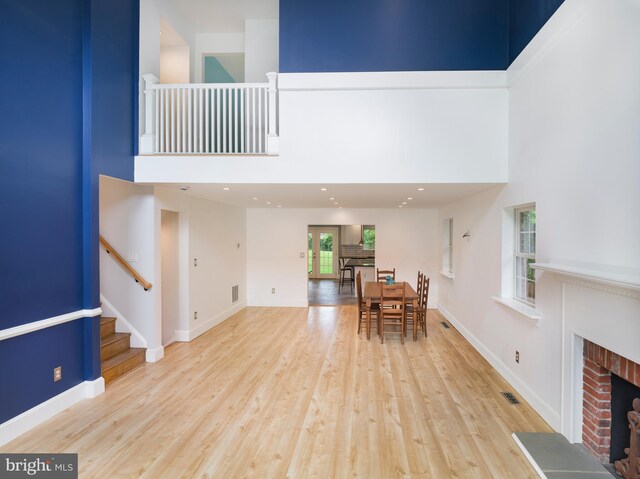 319 W Conestoga Rd, Devon, PA 19333 - dining space with a high ceiling, wood finished floors, a brick fireplace, and stairs