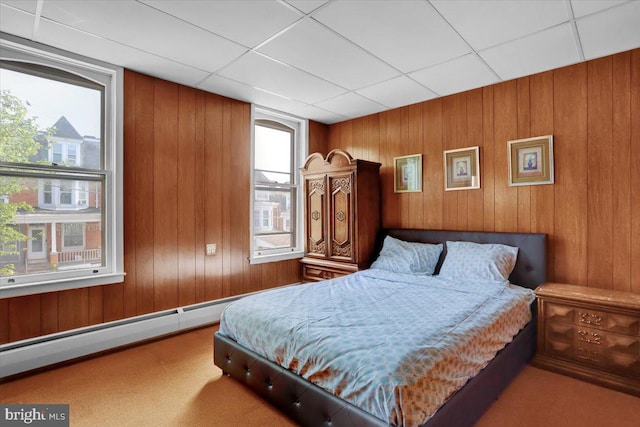 1243 Buttonwood St, Reading, PA 19604 - carpeted bedroom with a baseboard heating unit, wooden walls, and a paneled ceiling