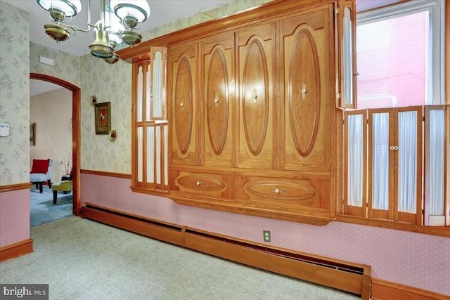 1243 Buttonwood St, Reading, PA 19604 - corridor featuring a baseboard radiator, wallpapered walls, arched walkways, carpet floors, and a chandelier
