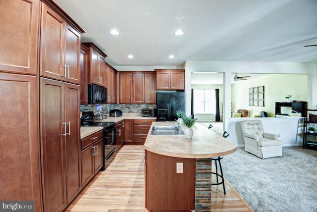 1814 S Pollock Way, Middletown, DE 19709 - kitchen with black appliances, ceiling fan, open floor plan, a kitchen island with sink, and light countertops