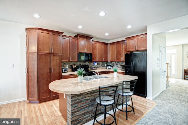 1814 S Pollock Way, Middletown, DE 19709 - kitchen featuring black appliances, light countertops, a breakfast bar area, tasteful backsplash, and a kitchen island with sink