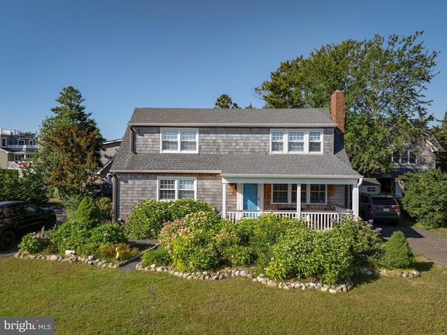 6 W 11th St, Barnegat Light, NJ 08006 - view of front of property featuring a chimney, a front lawn, a porch, and a shingled roof