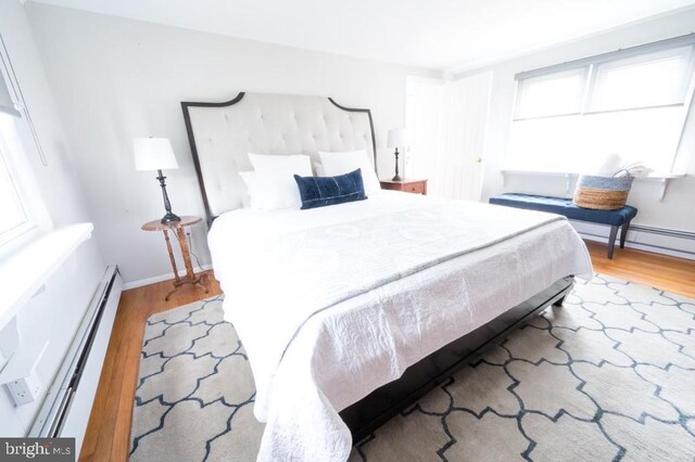 6 W 11th St, Barnegat Light, NJ 08006 - bedroom featuring wood finished floors and a baseboard heating unit