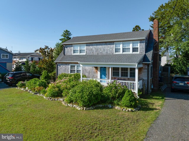 6 W 11th St, Barnegat Light, NJ 08006 - view of front of home featuring a front yard, a chimney, and roof with shingles