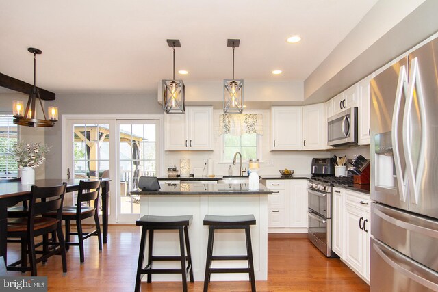 5997 Florey Rd, Hanover, MD 21076 - kitchen featuring stainless steel appliances, white cabinets, a kitchen island, wood finished floors, and recessed lighting