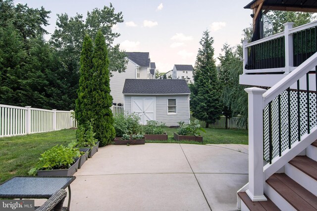5997 Florey Rd, Hanover, MD 21076 - fenced backyard featuring a vegetable garden, a storage unit, and a patio area