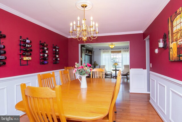 5997 Florey Rd, Hanover, MD 21076 - dining room featuring a chandelier, crown molding, wainscoting, wood finished floors, and a decorative wall