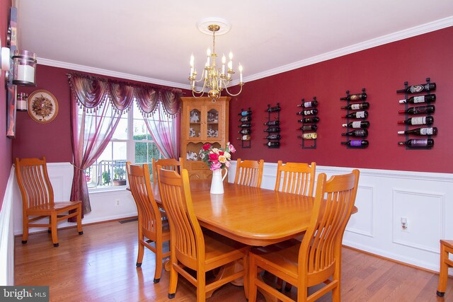 5997 Florey Rd, Hanover, MD 21076 - dining area with a chandelier, wood finished floors, ornamental molding, and wainscoting