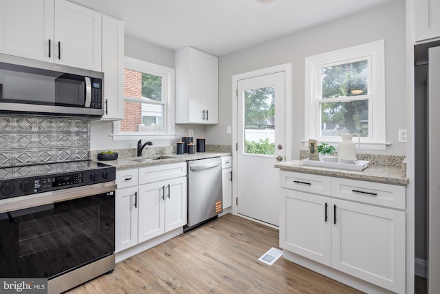 8207 Rockdale Ave, Baltimore, MD 21244 - kitchen with stainless steel appliances, light wood-style floors, white cabinetry, and light stone countertops