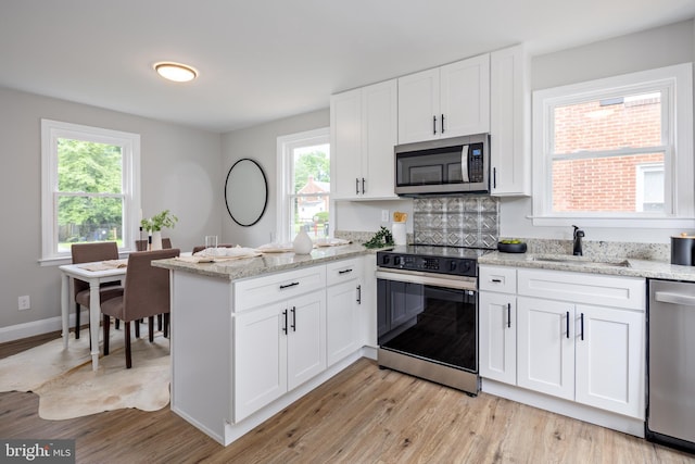 8207 Rockdale Ave, Baltimore, MD 21244 - kitchen with stainless steel appliances, a peninsula, and light wood-style flooring