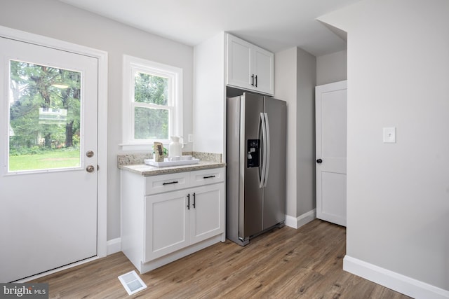 8207 Rockdale Ave, Baltimore, MD 21244 - kitchen with stainless steel fridge, light wood-style flooring, white cabinetry, and plenty of natural light