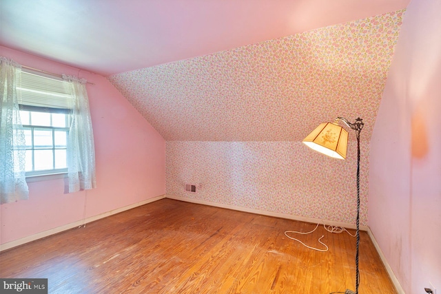 4513 Wards Chapel Rd, Owings Mills, MD 21117 - bonus room featuring wood finished floors, vaulted ceiling, and wallpapered walls