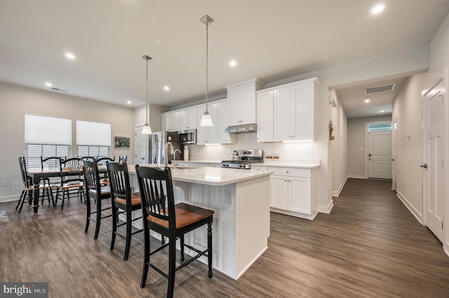 51 Old Forge Dr, Ocean View, DE 19970 - kitchen with stainless steel appliances, under cabinet range hood, a kitchen island with sink, dark wood-type flooring, and recessed lighting