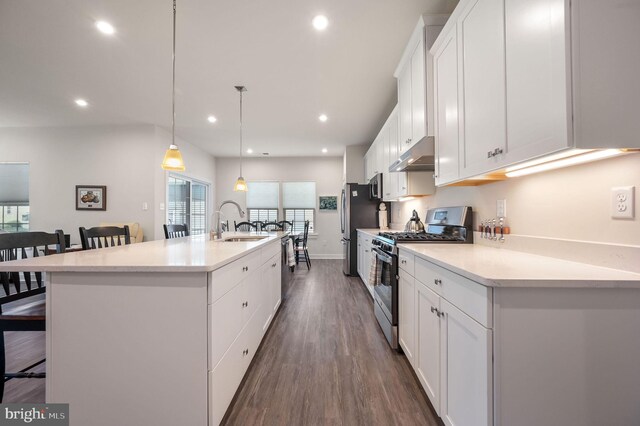51 Old Forge Dr, Ocean View, DE 19970 - kitchen featuring stainless steel appliances, under cabinet range hood, a kitchen bar, a center island with sink, and white cabinetry