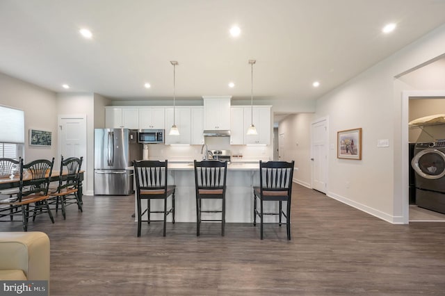 51 Old Forge Dr, Ocean View, DE 19970 - kitchen featuring appliances with stainless steel finishes, washer / clothes dryer, white cabinetry, an island with sink, and recessed lighting
