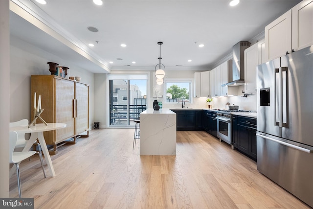 1117 Morse St NE Unit 3, Washington, DC 20002 - kitchen featuring stainless steel appliances, wall chimney range hood, ornamental molding, light wood-style flooring, and white cabinets