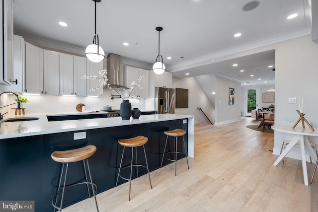 1117 Morse St NE Unit 3, Washington, DC 20002 - kitchen featuring high end refrigerator, wall chimney range hood, ornamental molding, light countertops, and white cabinets
