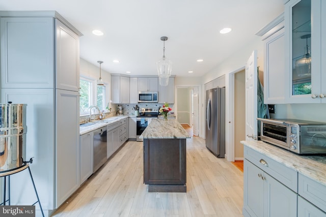 1439 Millikens Bend Rd, Herndon, VA 20170 - kitchen with stainless steel appliances, light wood-style floors, light stone counters, a kitchen island, and recessed lighting