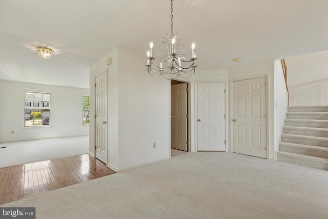 2408 Carriage Ln, Royersford, PA 19468 - unfurnished dining area with carpet, a chandelier, stairway, and hardwood / wood-style flooring