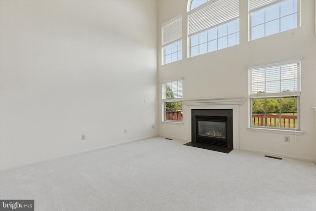 2408 Carriage Ln, Royersford, PA 19468 - unfurnished living room featuring carpet flooring, a towering ceiling, and a fireplace with flush hearth