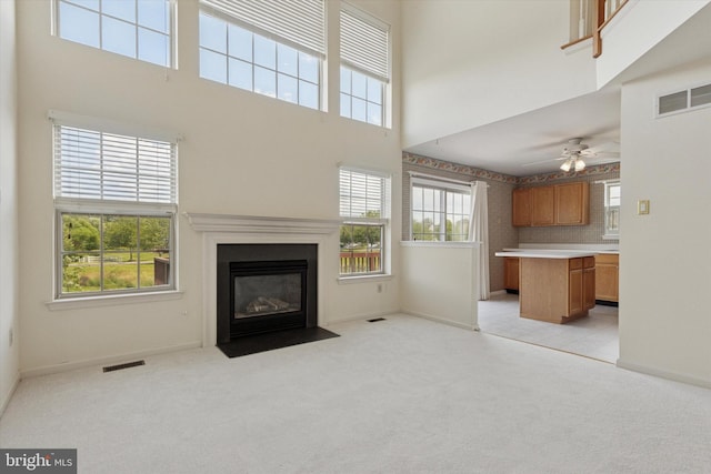 2408 Carriage Ln, Royersford, PA 19468 - unfurnished living room with a high ceiling, light colored carpet, ceiling fan, and a fireplace with flush hearth