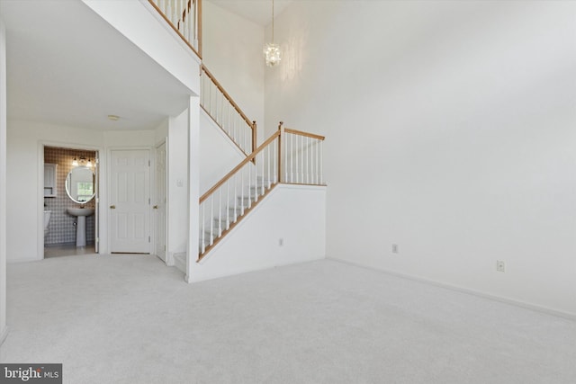 2408 Carriage Ln, Royersford, PA 19468 - unfurnished living room with stairway, carpet, a chandelier, and a high ceiling