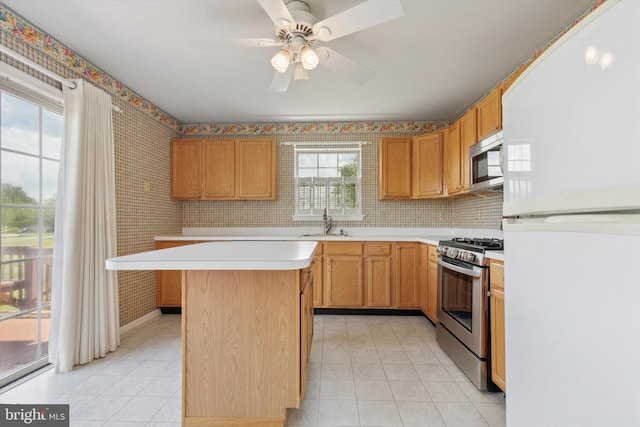 2408 Carriage Ln, Royersford, PA 19468 - kitchen featuring appliances with stainless steel finishes, light countertops, wallpapered walls, light tile patterned floors, and ceiling fan