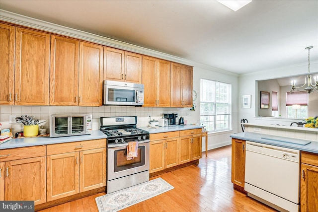 16 Monte Carlo Dr, Hamilton, NJ 08691 - kitchen featuring appliances with stainless steel finishes, light wood-style floors, crown molding, decorative backsplash, and a chandelier