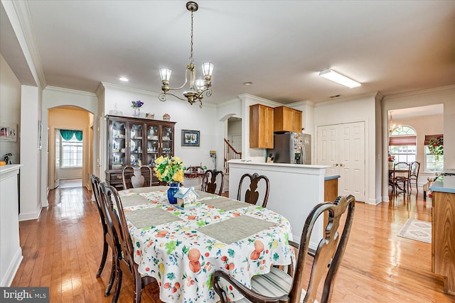 16 Monte Carlo Dr, Hamilton, NJ 08691 - dining area with arched walkways, ornamental molding, a chandelier, and light wood finished floors