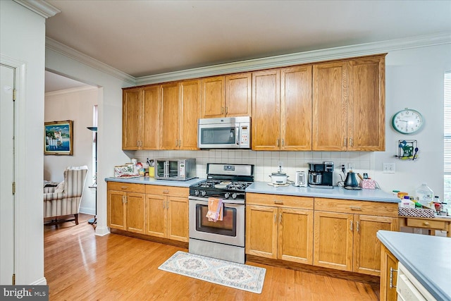 16 Monte Carlo Dr, Hamilton, NJ 08691 - kitchen featuring appliances with stainless steel finishes, light wood-style flooring, crown molding, decorative backsplash, and light countertops