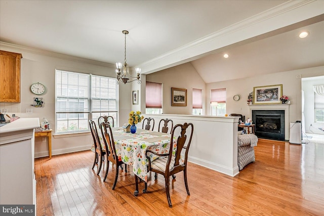 16 Monte Carlo Dr, Hamilton, NJ 08691 - dining room with a chandelier, light wood finished floors, ornamental molding, lofted ceiling, and a glass covered fireplace
