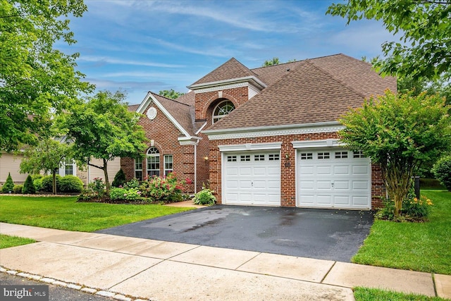 16 Monte Carlo Dr, Hamilton, NJ 08691 - traditional-style house with brick siding, an attached garage, driveway, a front lawn, and a shingled roof
