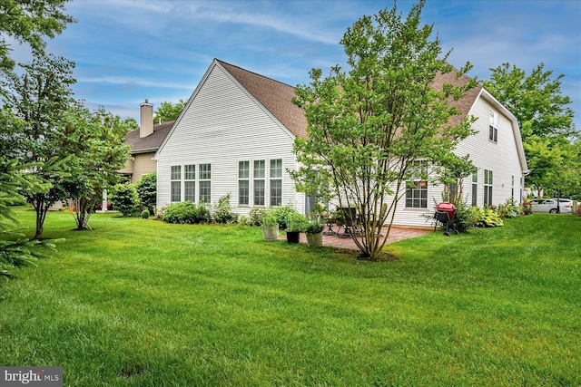 16 Monte Carlo Dr, Hamilton, NJ 08691 - back of house with a patio, a shingled roof, a chimney, and a yard