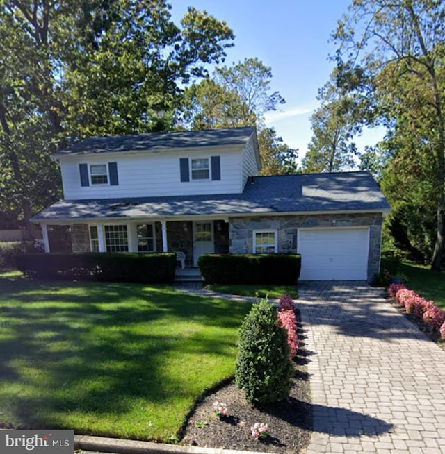 202 Patricia Ave, Millville, NJ 08332 - traditional-style house featuring stone siding, an attached garage, decorative driveway, and a front yard