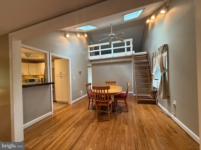 1731 Columbia Beach Rd, Shady Side, MD 20764 - dining area with a skylight, ceiling fan, high vaulted ceiling, light wood finished floors, and rail lighting