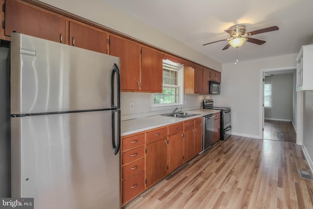 830 William St, Front Royal, VA 22630 - kitchen with stainless steel appliances, light countertops, light wood-style floors, brown cabinets, and ceiling fan