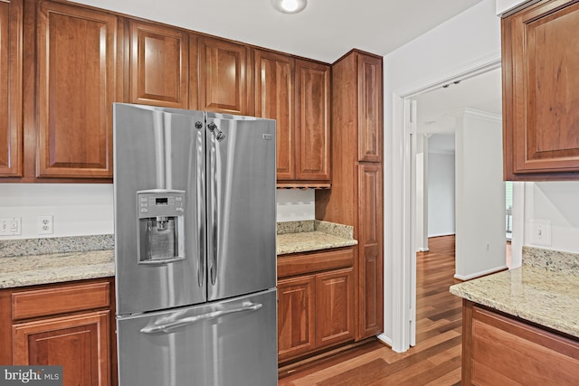 9405 Odyssey Ct, Burke, VA 22015 - kitchen with stainless steel fridge, wood finished floors, brown cabinets, and light stone counters