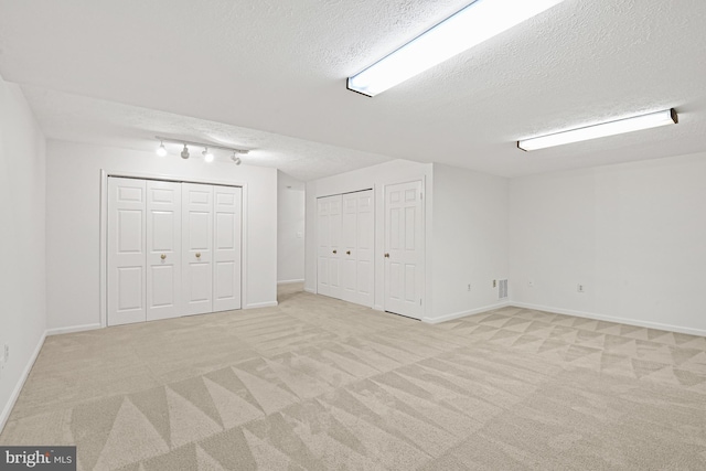 9405 Odyssey Ct, Burke, VA 22015 - basement featuring a textured ceiling, light carpet, and track lighting