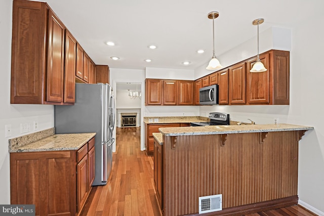 9405 Odyssey Ct, Burke, VA 22015 - kitchen with stainless steel appliances, a peninsula, light wood-style flooring, a breakfast bar area, and recessed lighting