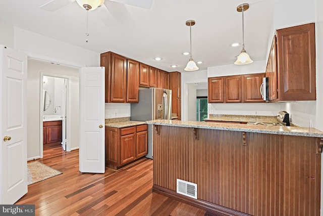 9405 Odyssey Ct, Burke, VA 22015 - kitchen featuring stainless steel appliances, light wood-style flooring, light stone counters, a peninsula, and recessed lighting