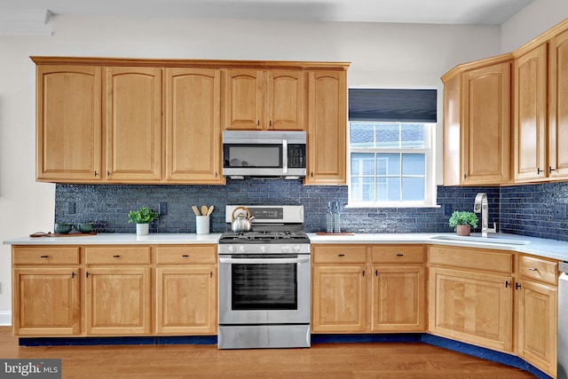 32 Brewster Ct, Pennington, NJ 08534 - kitchen with appliances with stainless steel finishes, light brown cabinetry, light countertops, backsplash, and light wood-type flooring