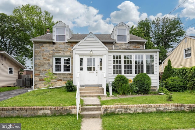 661 Schoolside Ln, Swarthmore, PA 19081 - new england style home with stone siding, a front yard, a shingled roof, and a chimney