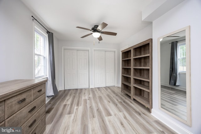 661 Schoolside Ln, Swarthmore, PA 19081 - unfurnished bedroom with two closets, wood finished floors, multiple windows, and a ceiling fan