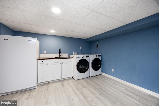 661 Schoolside Ln, Swarthmore, PA 19081 - laundry area featuring washer and dryer, cabinet space, and light wood-type flooring